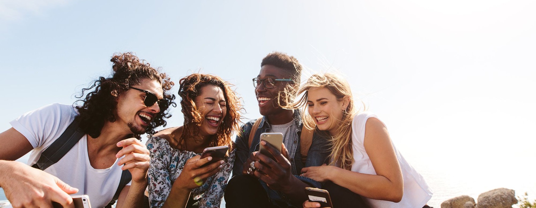 friends looking at phones and laughing 